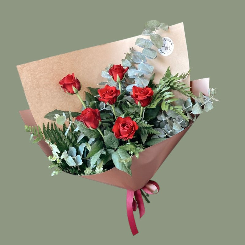 6 red roses wrapped in brown paper