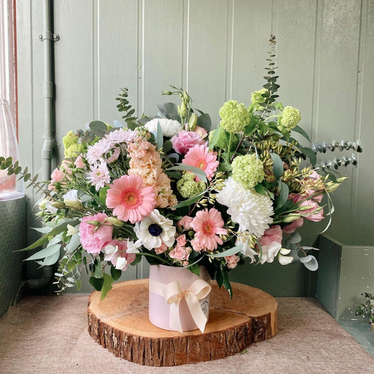 Buderim Floral Art, Sunshine Coast Florist offering same day flower delivery. Beautiful fresh flowers, a large bouquet of flowers, includingpink flowers, white flowers sitting on a timber board. 
