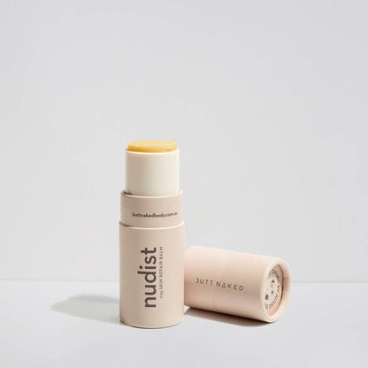 Two cylindrical beauty products with 'nudist' branding on a light gray background