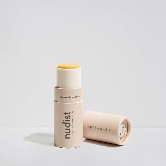 Two cylindrical beauty products with 'nudist' branding on a light gray background