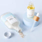 Cosmetic products including a bottle, dropper, and jar on a light blue background