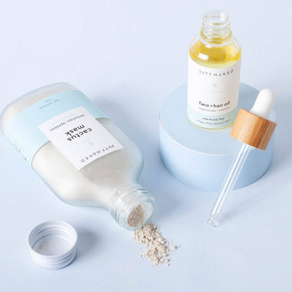 Cosmetic products including a bottle, dropper, and jar on a light blue background