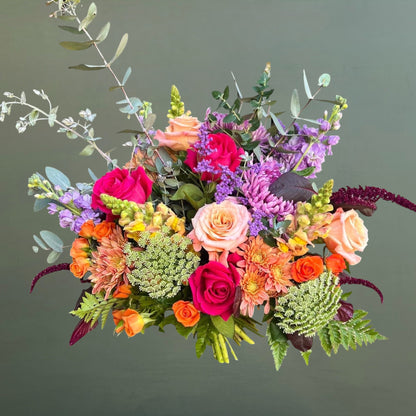 Colorful flower bouquet with roses and greenery on a dark background