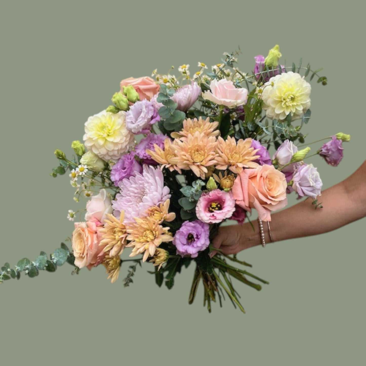 Bouquet of colorful flowers held by a person against a plain background