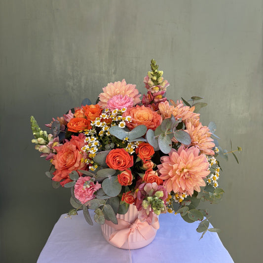 Bouquet of flowers in a vase on a white tablecloth with a gray background