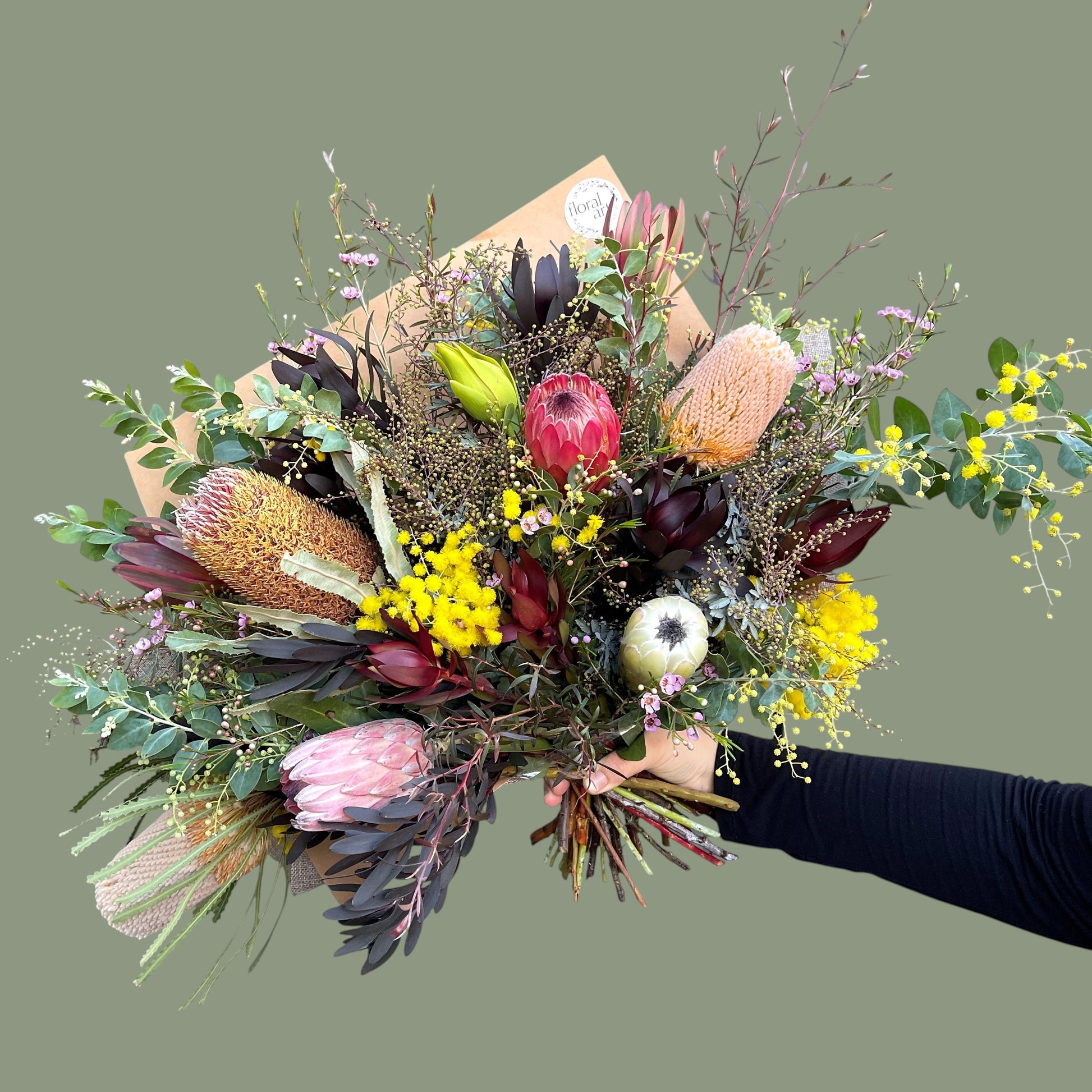 Bouquet of flowers held by a person against a plain background