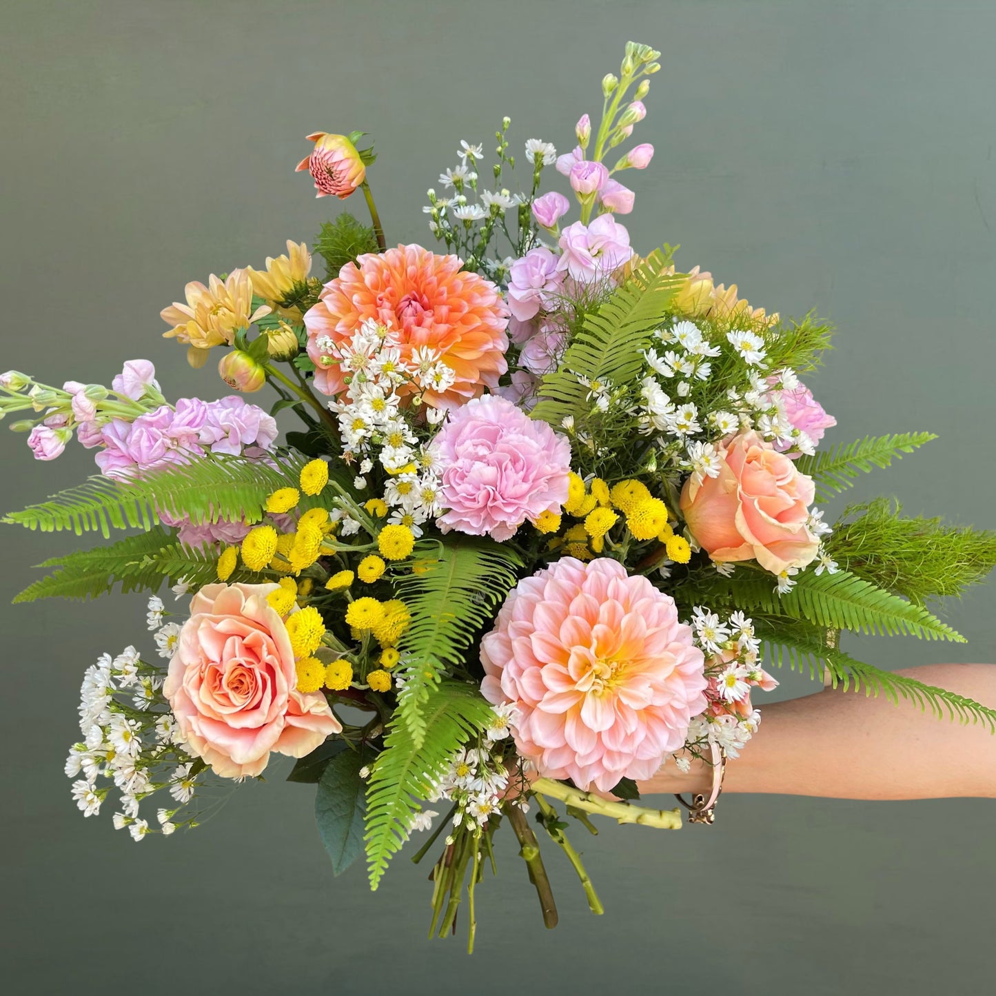Bouquet of flowers with pink, yellow, and green colors on a green background