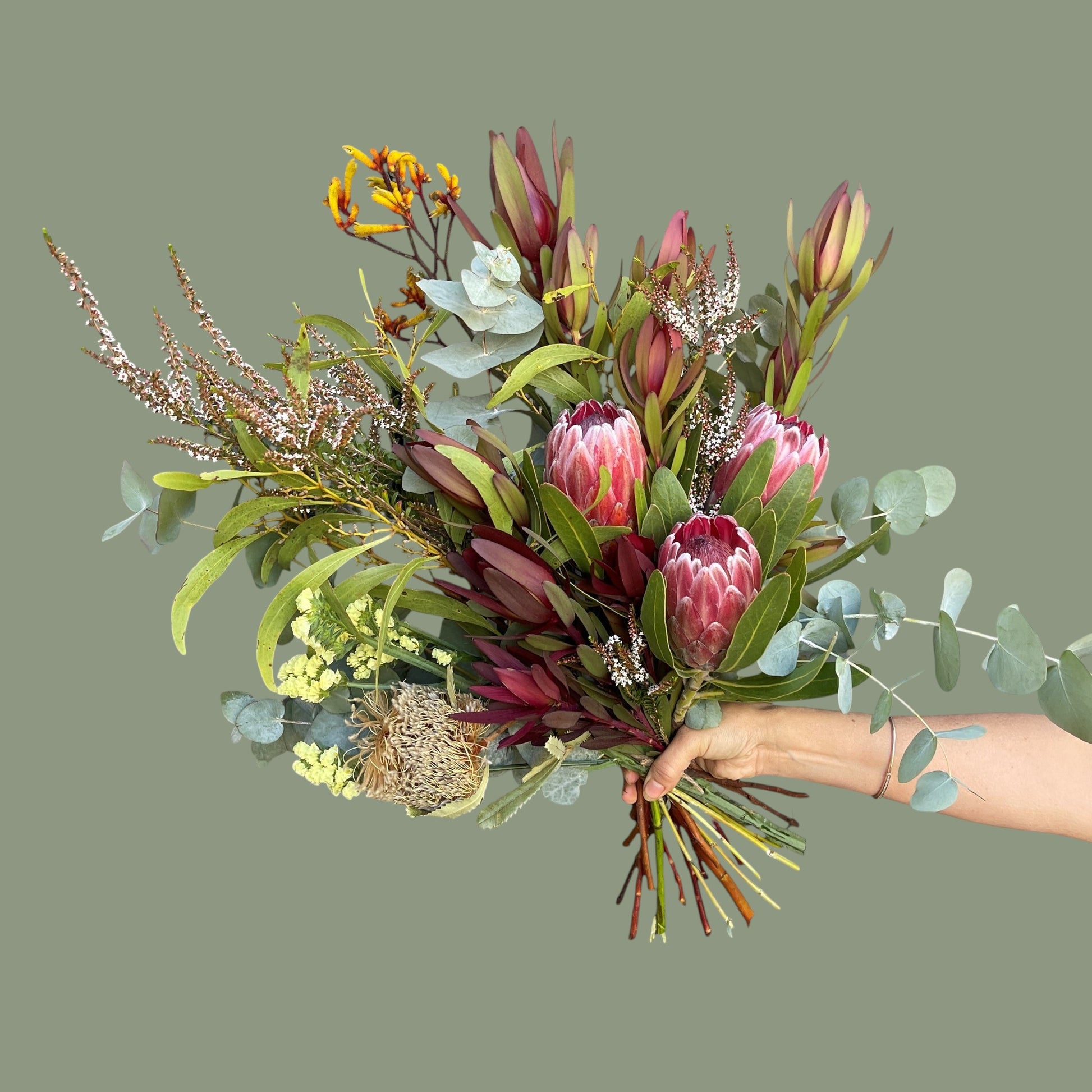 Bouquet of flowers held by a hand on a plain background