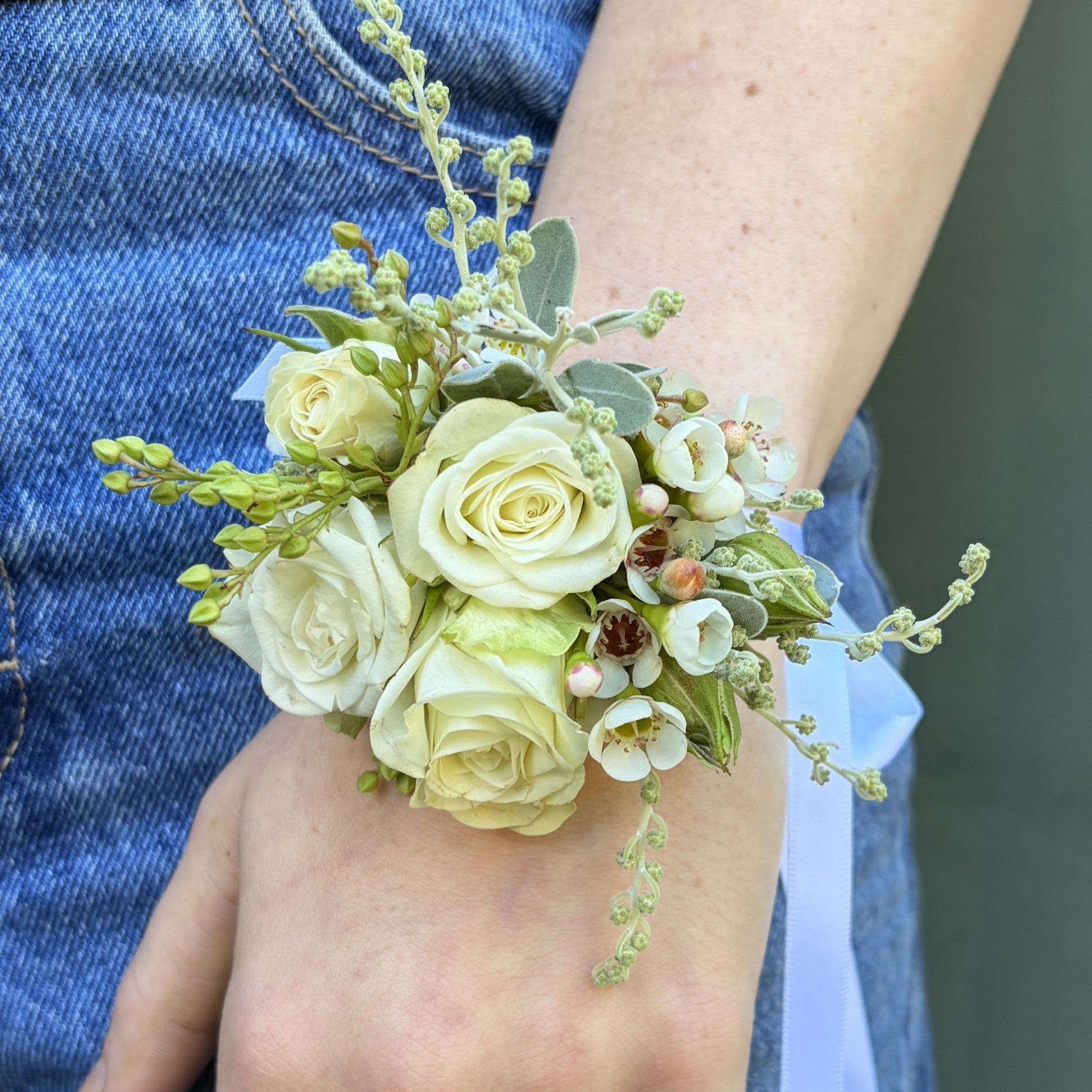 Floral corsage on a wrist with a blurred background

