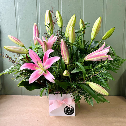 Oriental Lilies arranged in a box with foliage