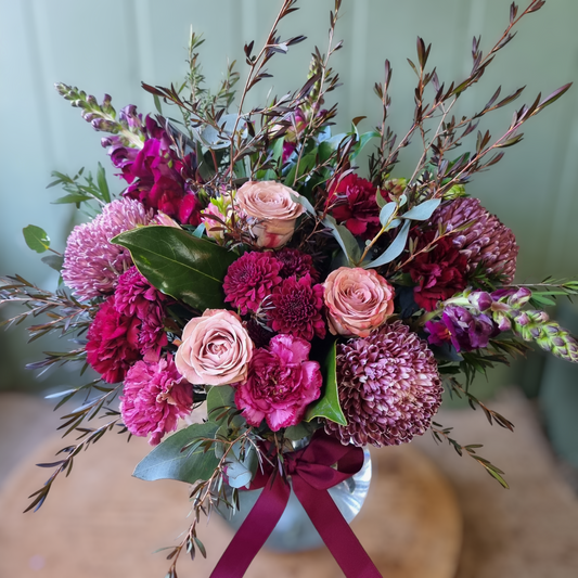 Burgundy coloured bold flowers arranged in a vase