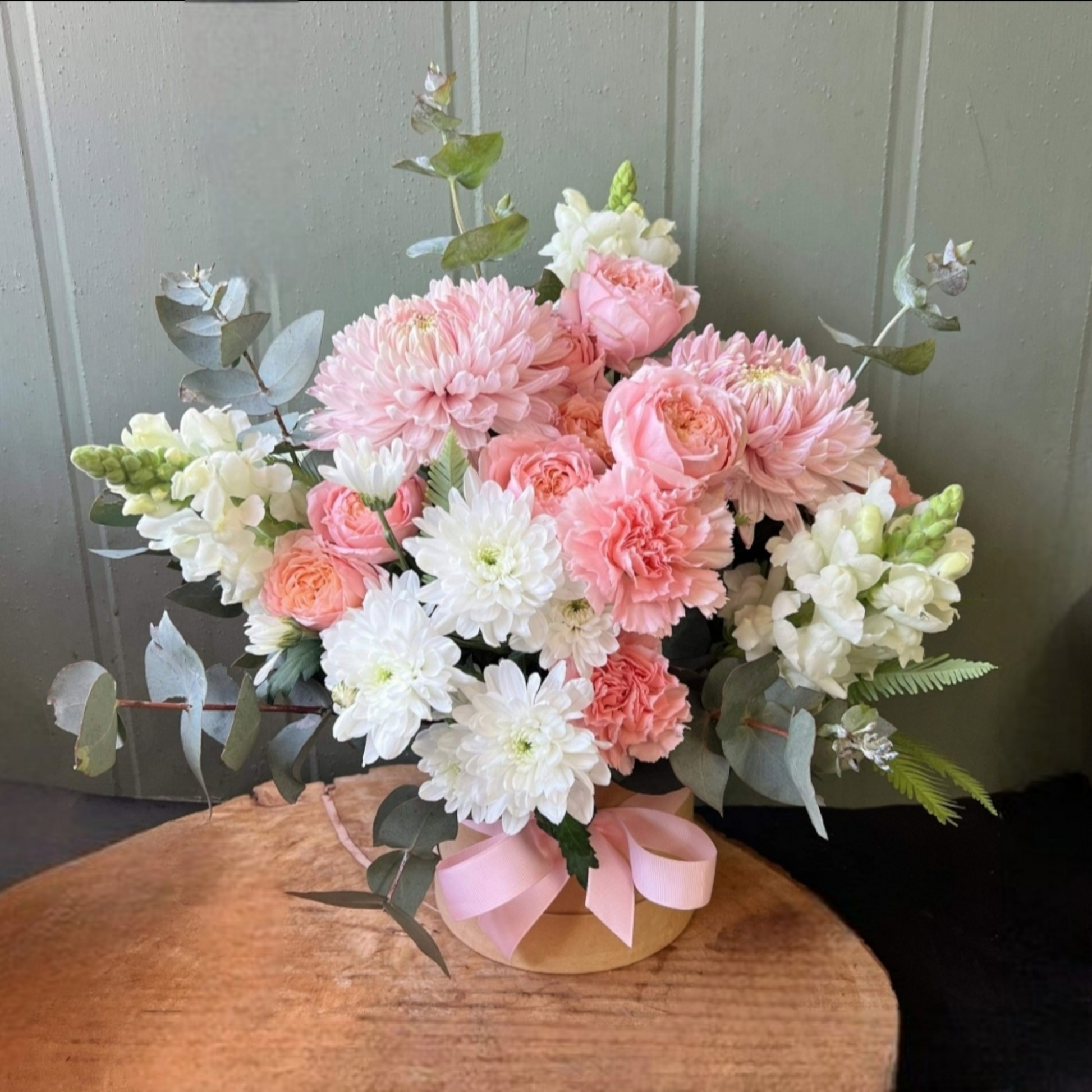 Pink and white tonal flowers arranged in a hatbox