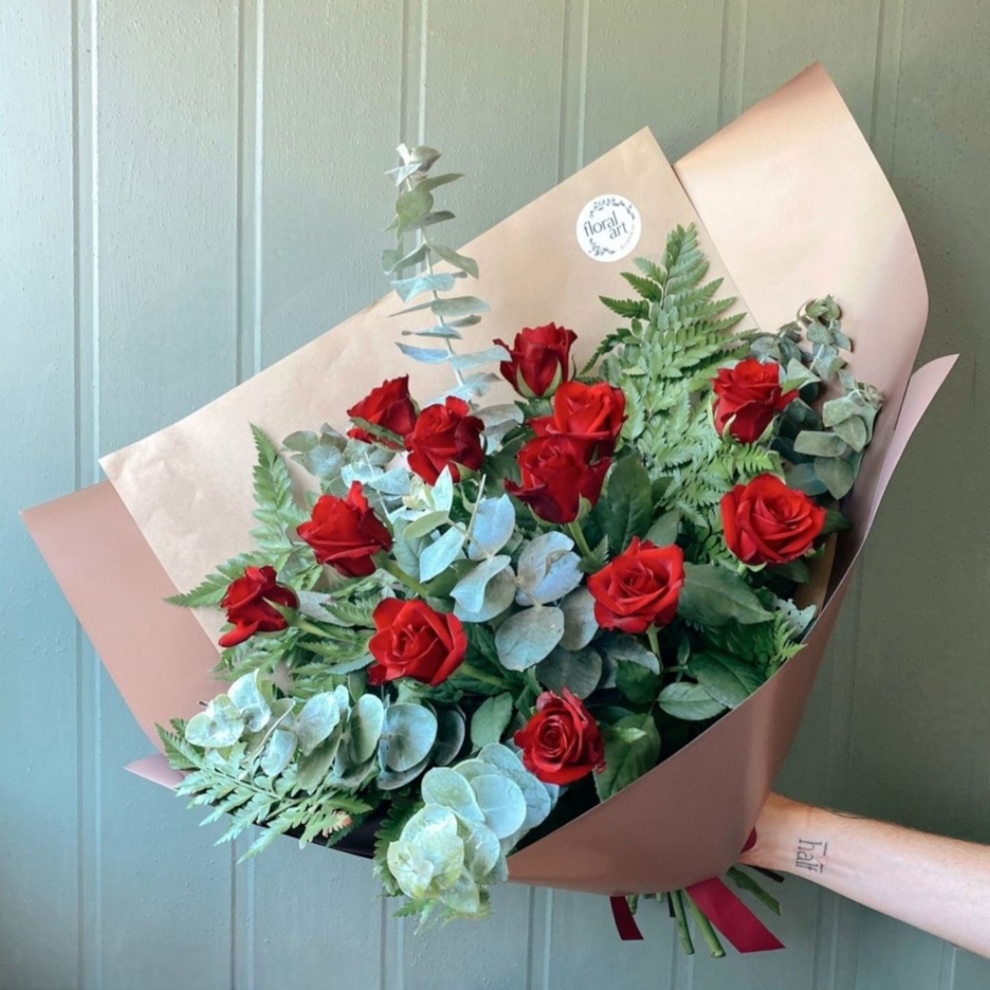 12 red roses and foliages in a bouquet