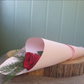 Single rose and foliage wrapped in paper