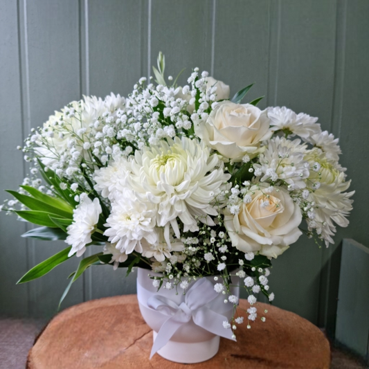 White seasonal flowers arranged in a ceramic vase
